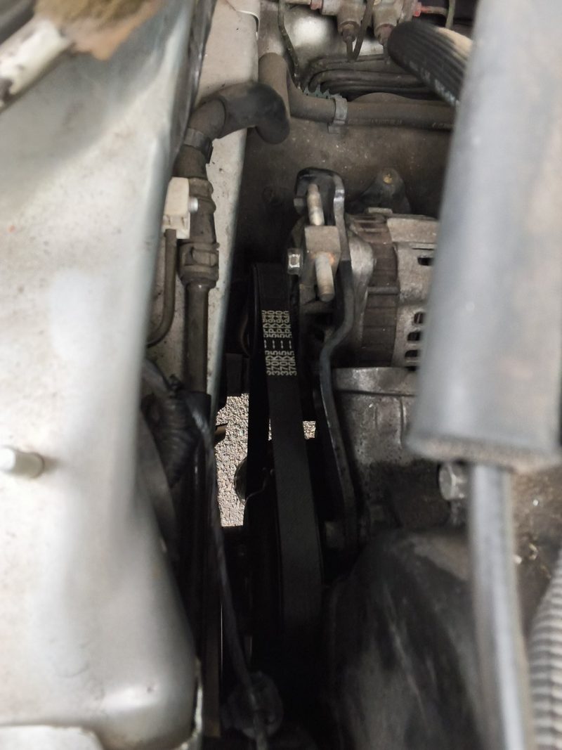 The new serpentine belt routed around the pulleys at the side of the Eclipse engine
