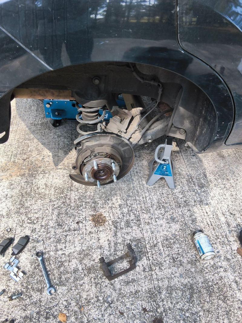 Kia Soul on a jack stand with the wheel off and the brake hub exposed