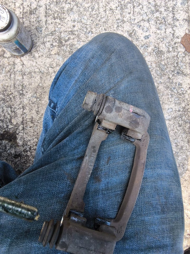 A rusty caliper bracket from the Kia Soul held up during the brake job