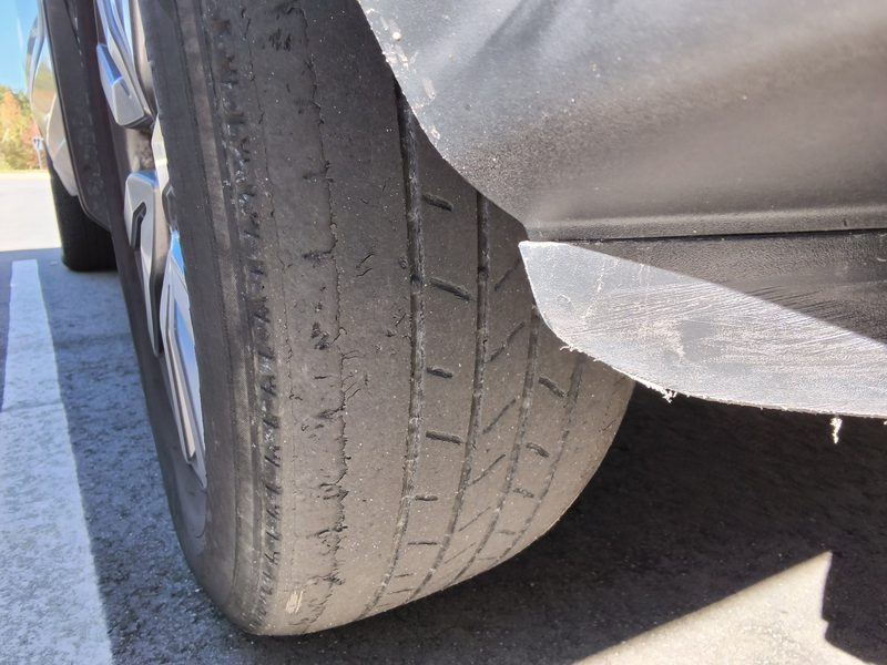 A front tire on the Honda Pilot with tread worn down along one edge